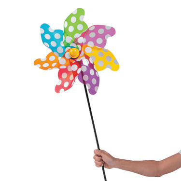 Colorful polka dot windmill held by a hand on a white background